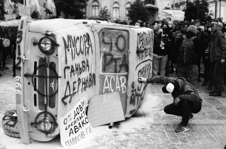 black and white po of a person holding a van in front of a crowd of people