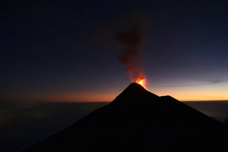 a long exposure po of a large fire rising from the summit