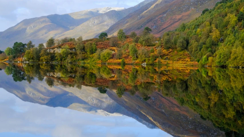 a mountain landscape with reflections on the still water