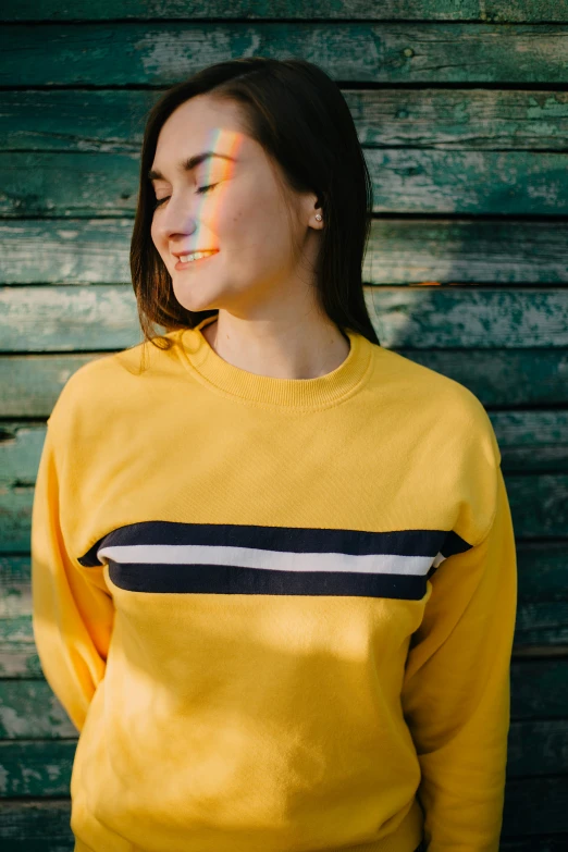 woman in a yellow sweater is standing close to the camera