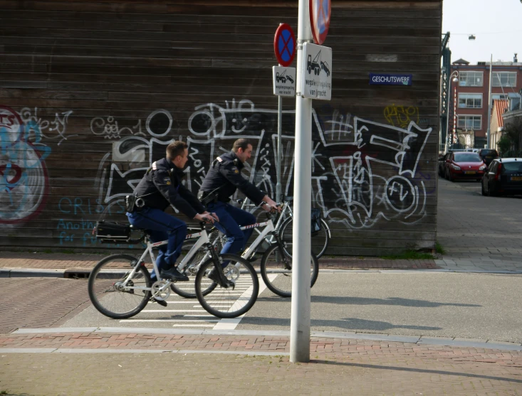 two women riding bicycles down a street