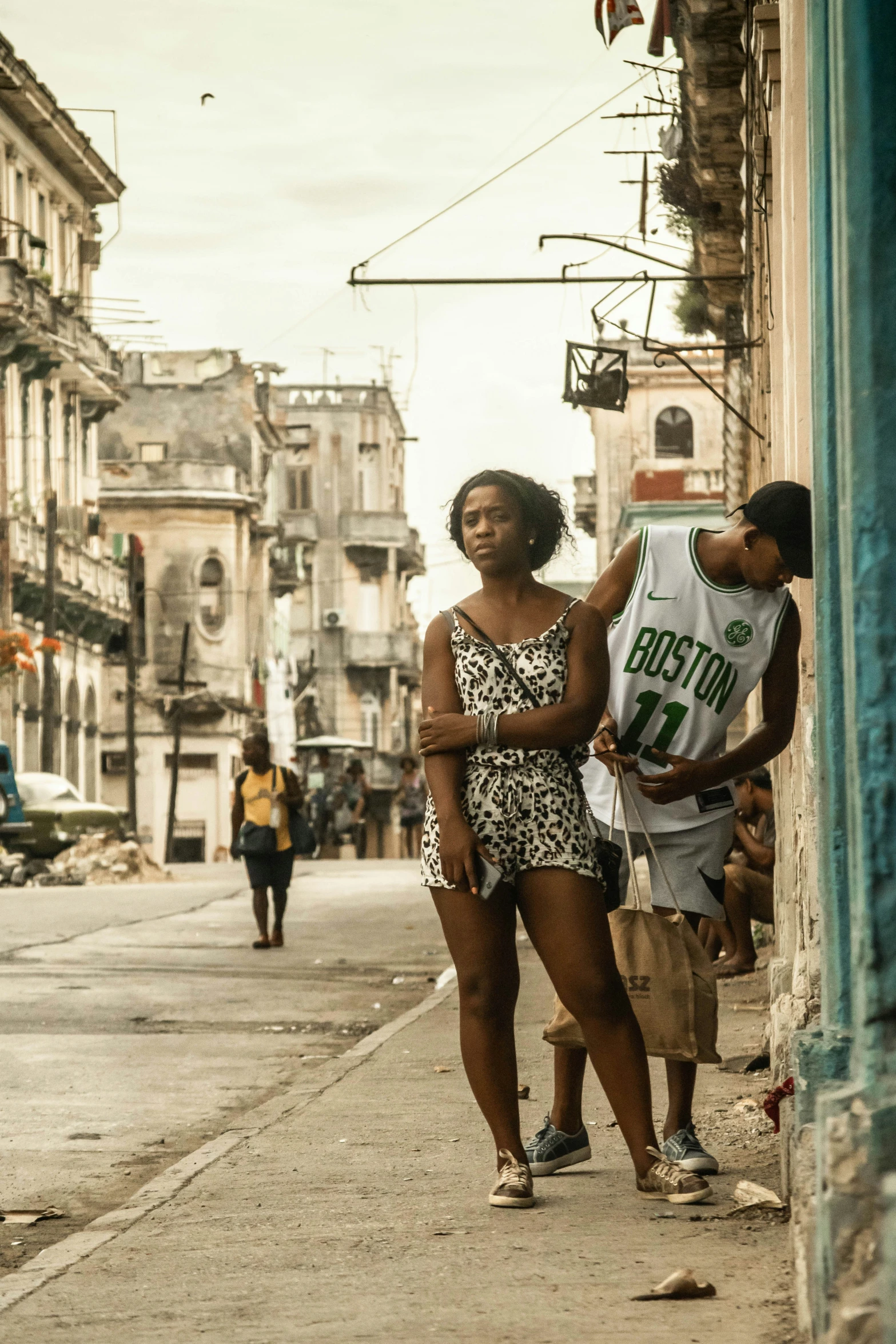 two girls walking down the sidewalk on the side of the street