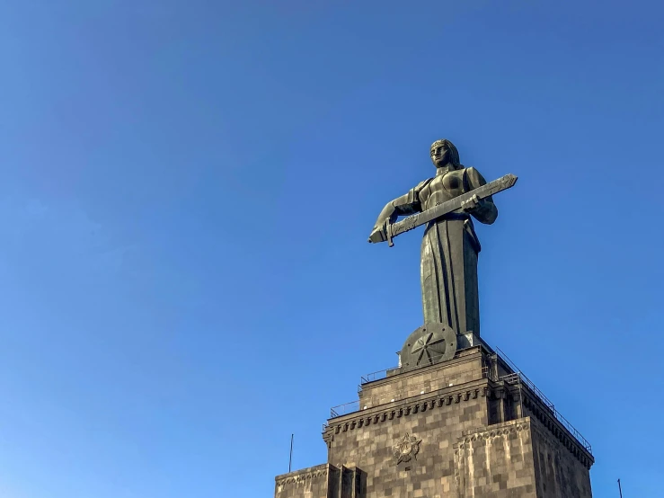 an enormous statue atop a tall building