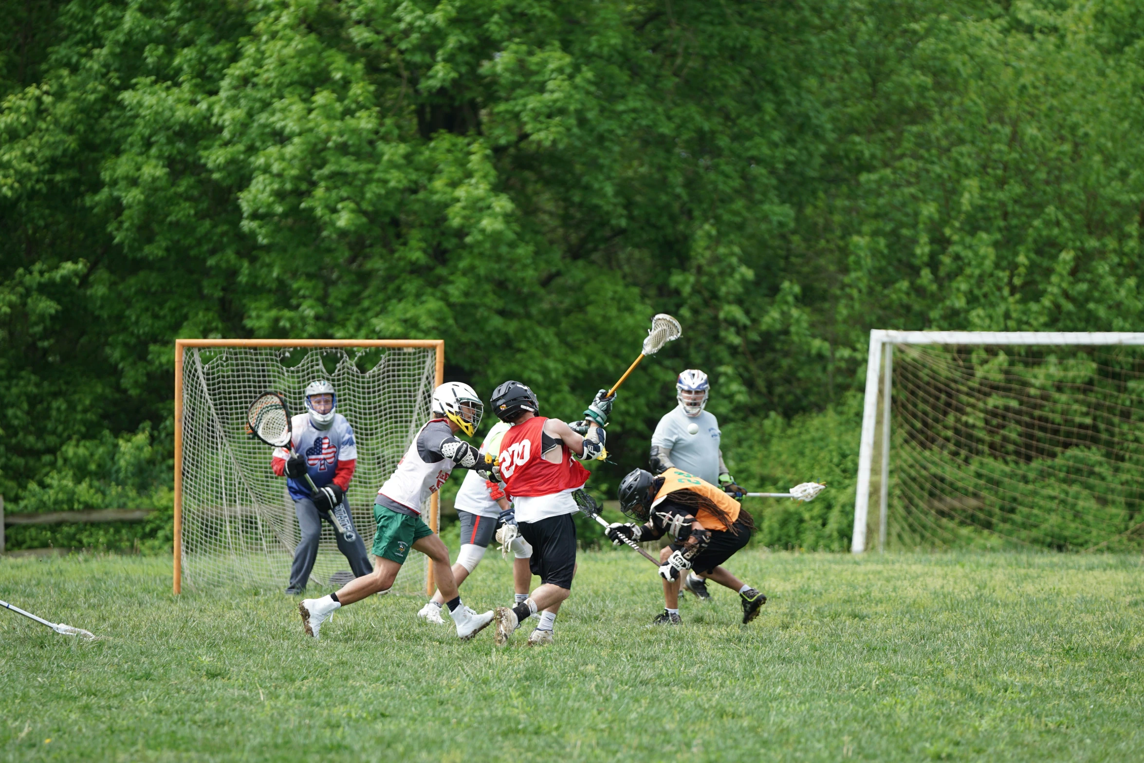 many young children playing a game of lacrosse