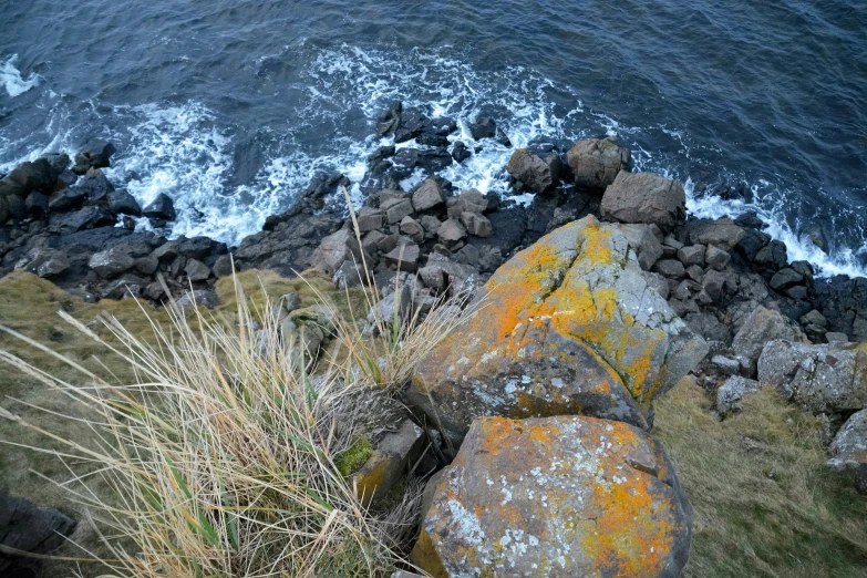 an ocean and rocks area on the edge of a cliff