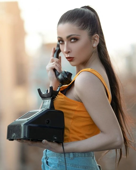 a woman in an orange tank top talks on her cell phone