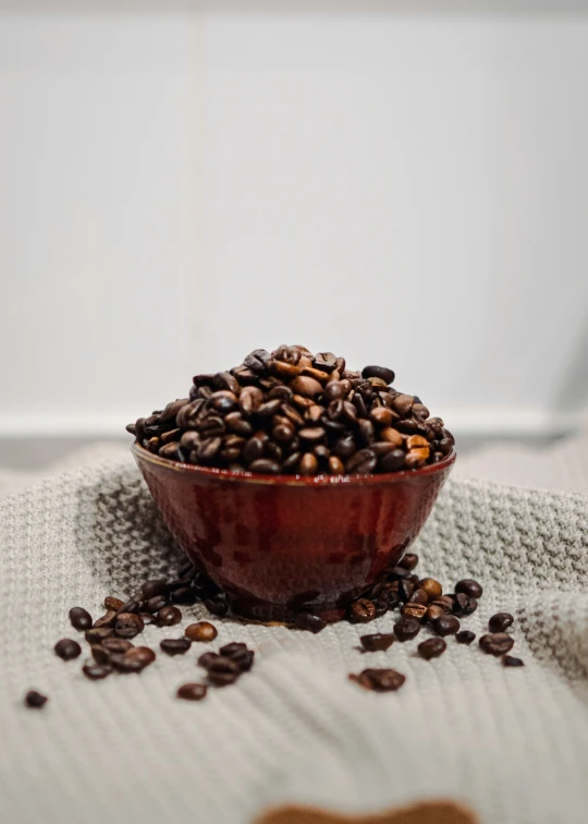 a bowl full of coffee beans sitting on a table