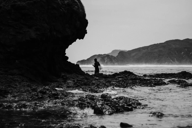 a person standing on rocks in the water