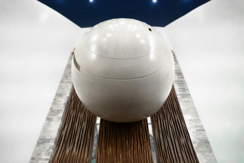 a big white ball sits underneath an umbrella