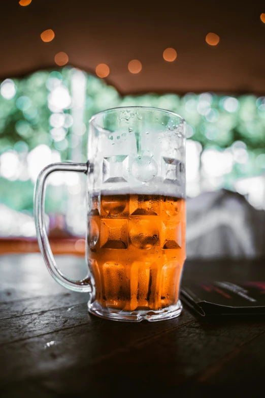 a glass full of beer next to an iphone