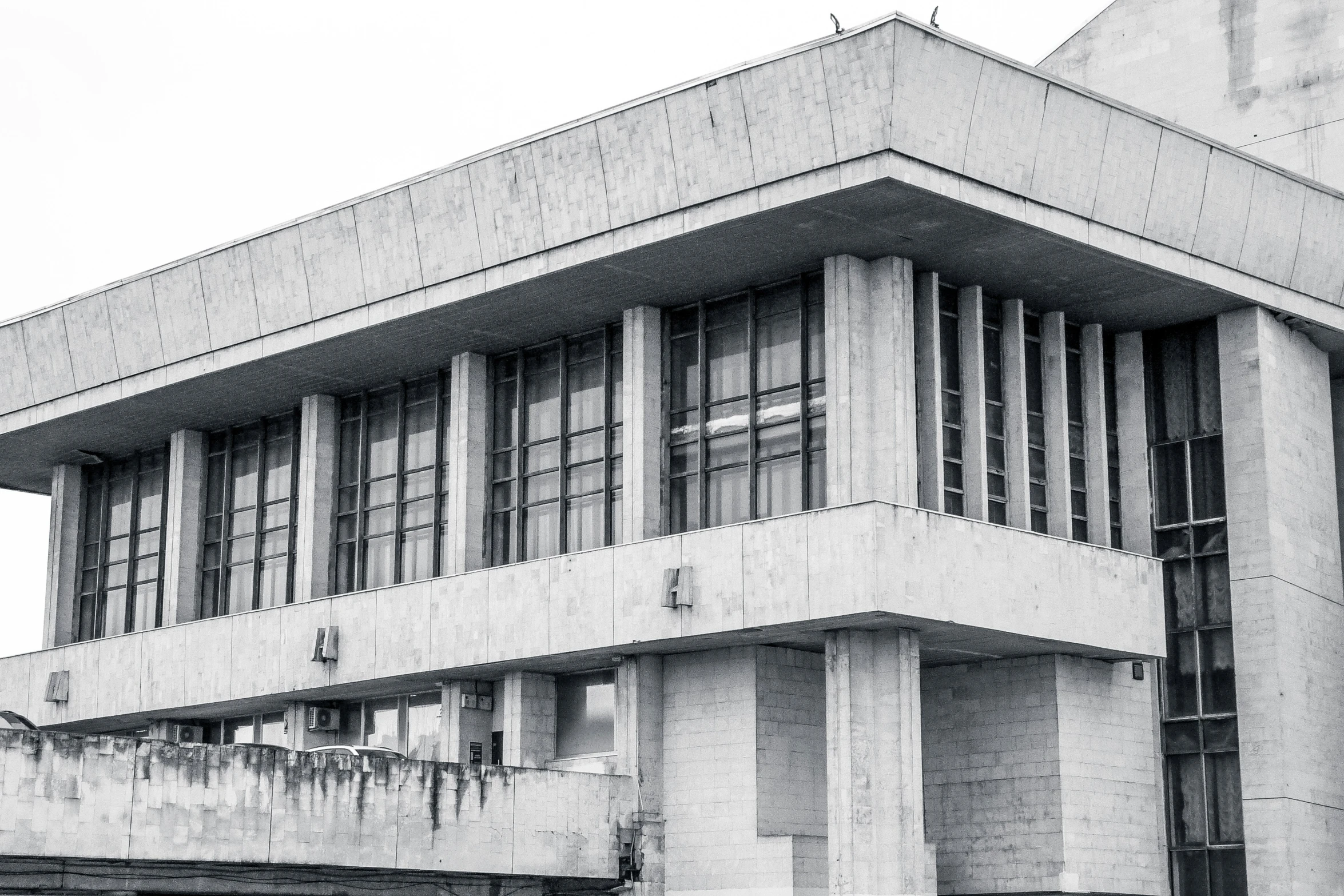 black and white pograph of a building with windows and a roof