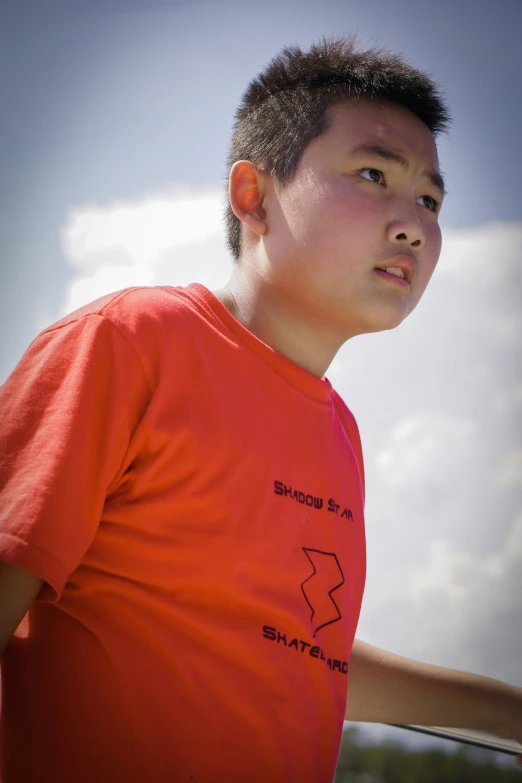 a man wearing an orange t - shirt with a bird design on it