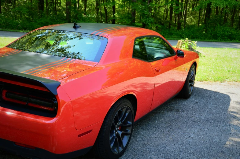 a large orange car parked on top of a street