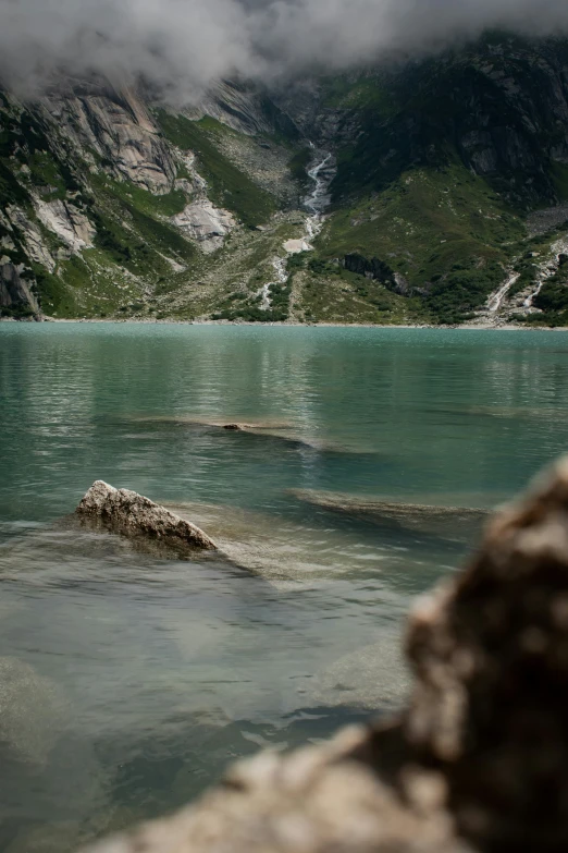 a body of water with a very large hill in the background