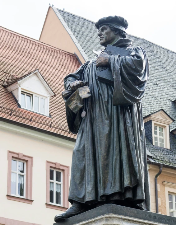 a statue of a monk next to a building