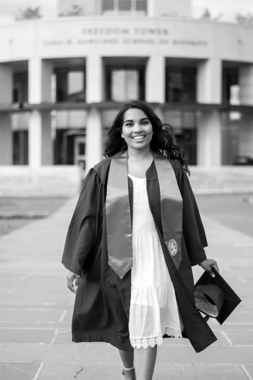 a smiling woman in a graduation gown and hat