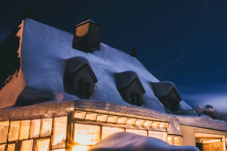 a large house that is under some snow at night