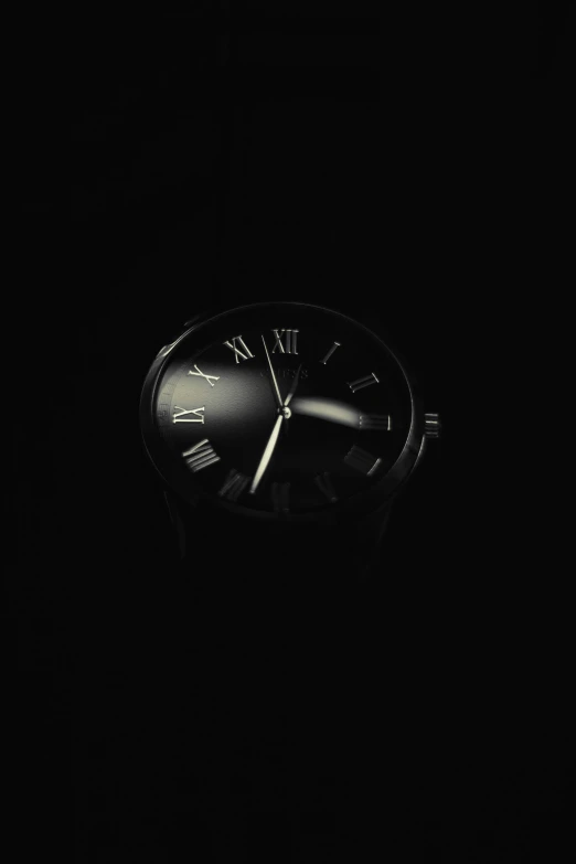 there is a black clock illuminated in the dark