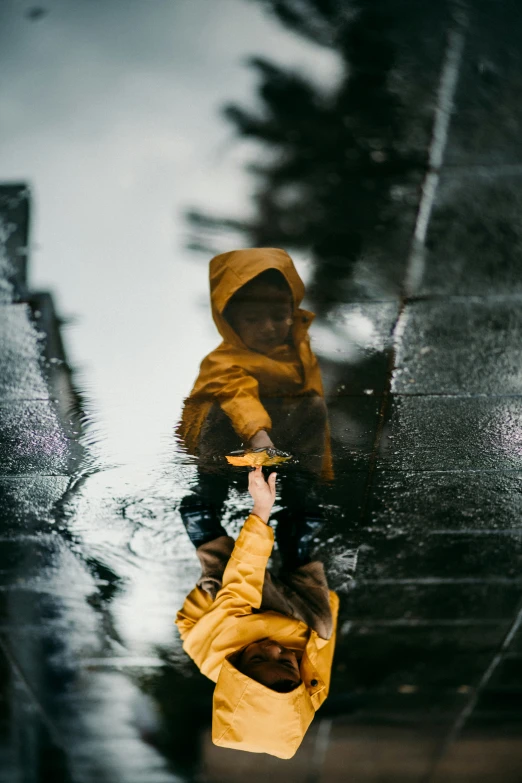 two people are reflected in water under an umbrella