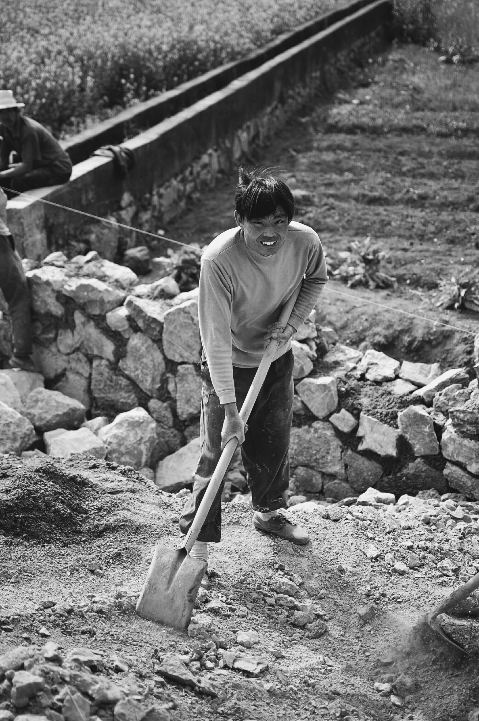 two boys digging rocks to repair the train tracks