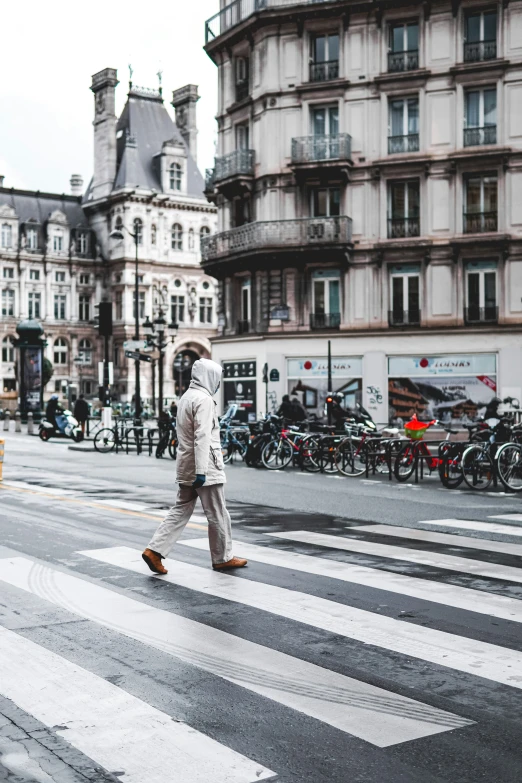 a man walks across the street with an umbrella over his head