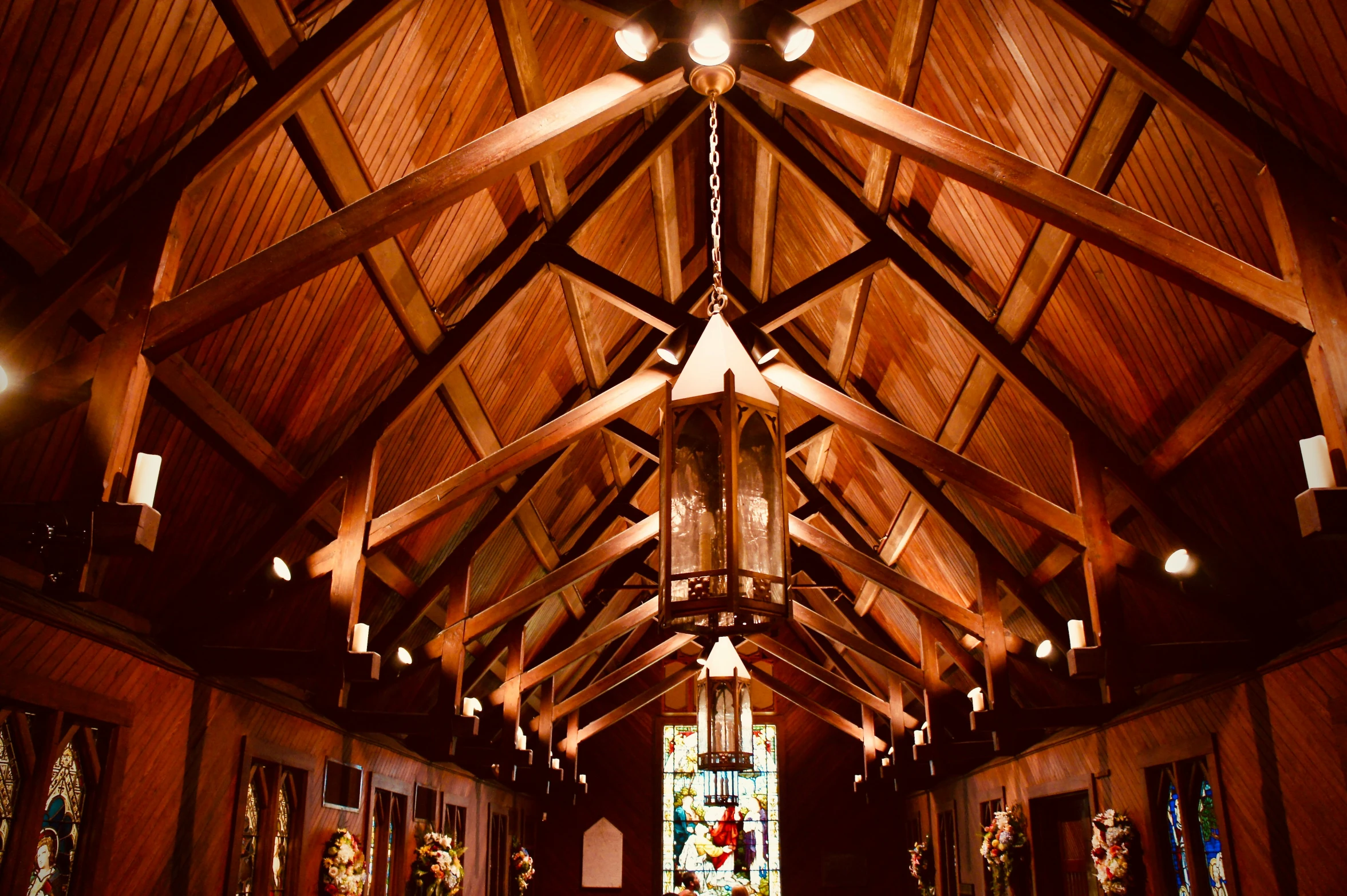 an empty church with wood beams and a stain glass window