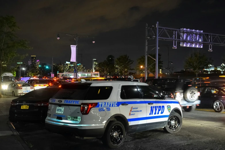 several police cars sit parked at night on the highway