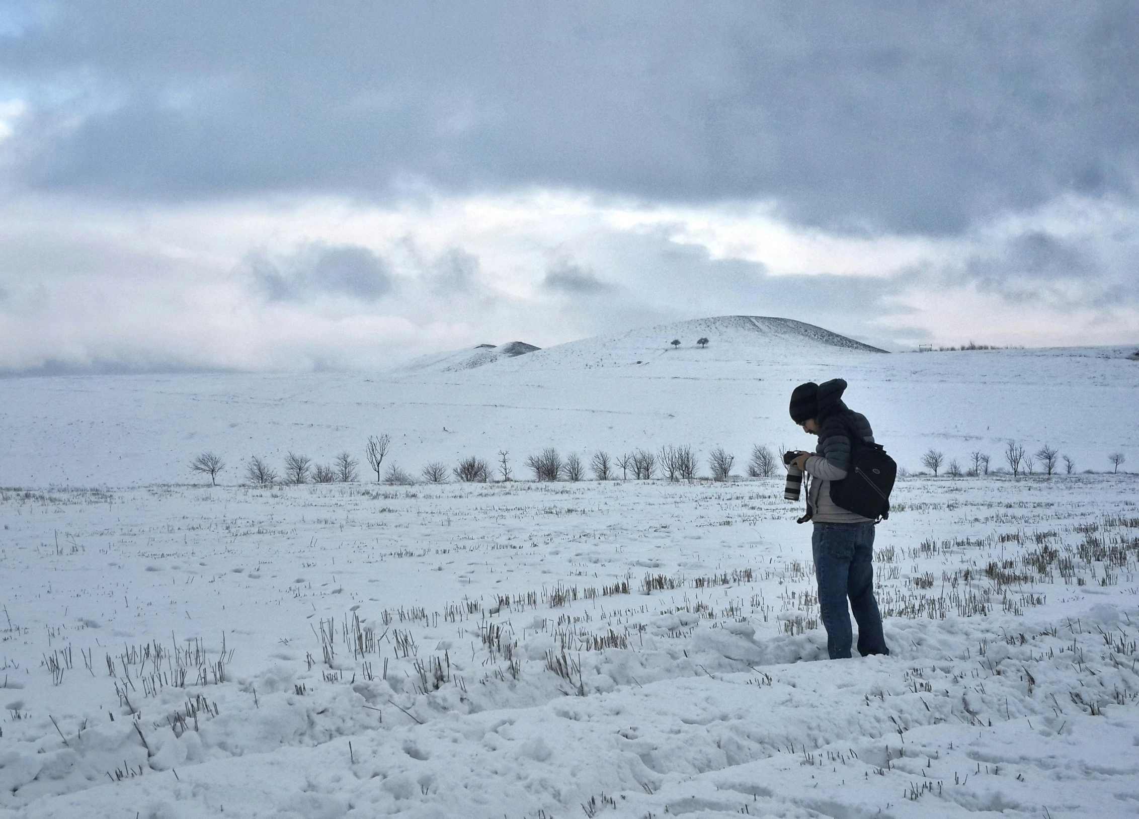 the girl in the snow stands alone and watches the sky