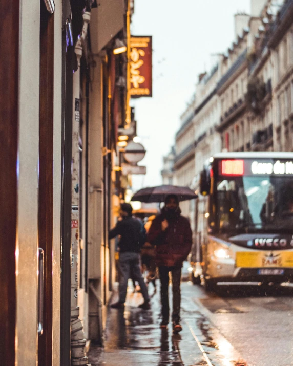 there are people walking down the street with an umbrella