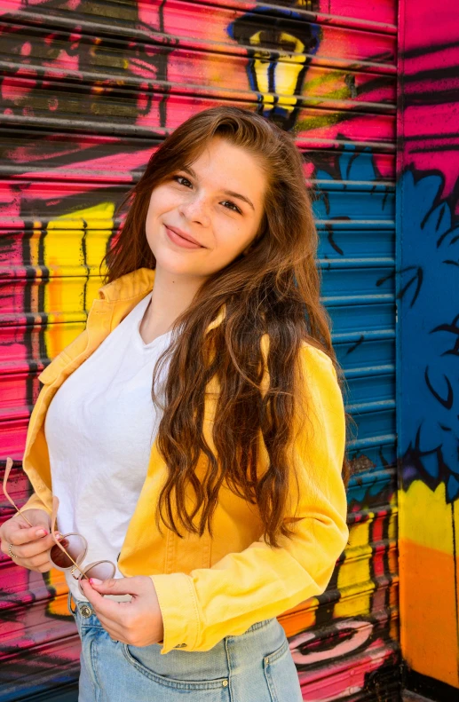  in jeans posing for portrait against colorful background