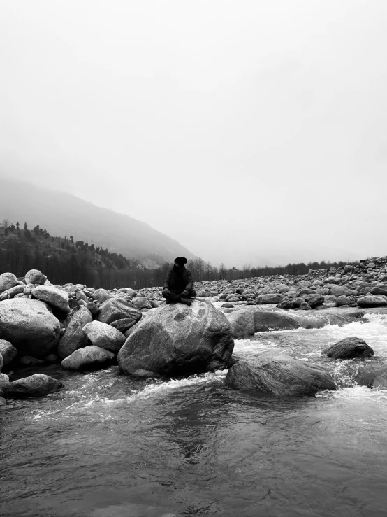 a man standing on a rock near water