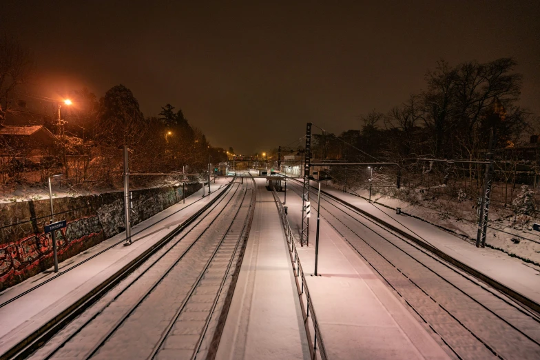 a snowy city scene, with trains on the tracks