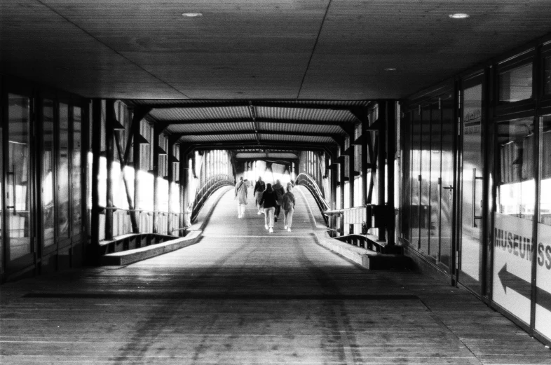 the inside of a train tunnel with people walking on it