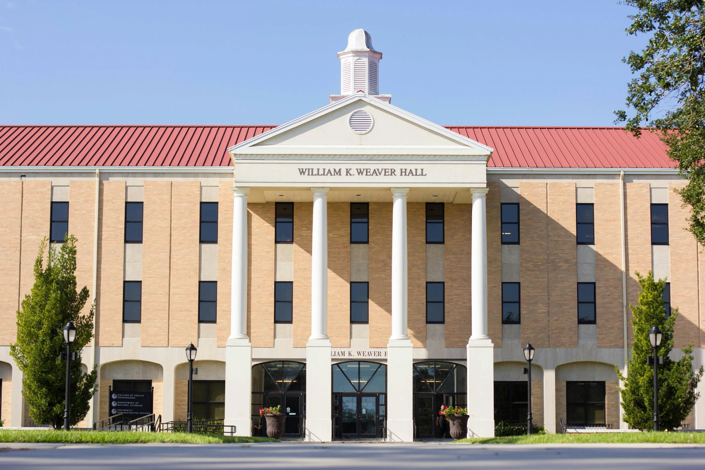 an image of a large building that is tan and has red tiled roof