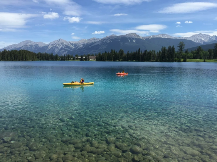 two people in yellow rafts on a clear lake