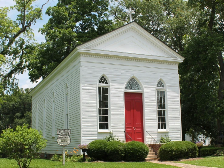 a white church building with a red door on it