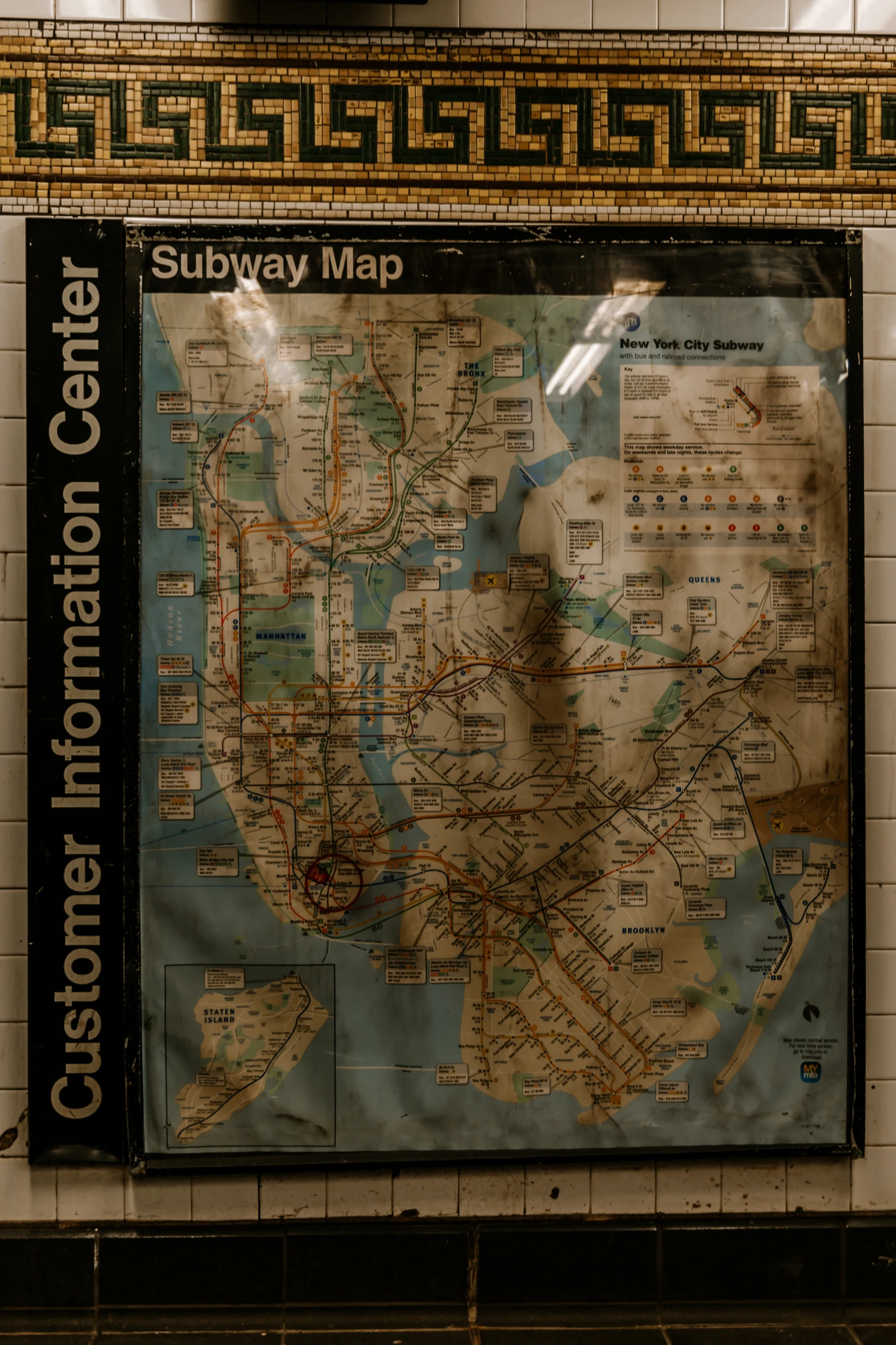 an old subway map hanging up on a wall