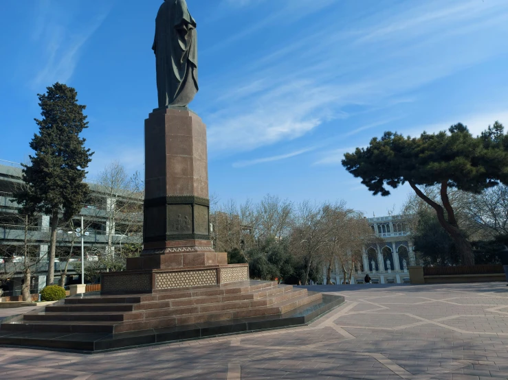 a statue sitting on top of a wooden pole