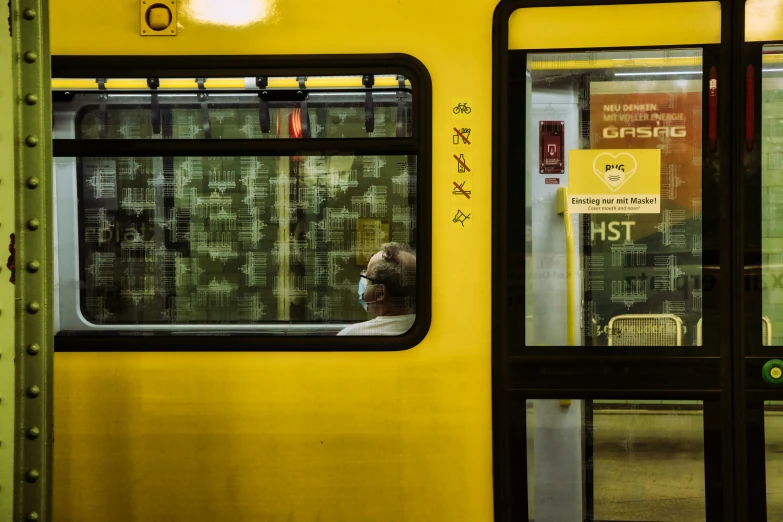 people that are looking out of a yellow train window