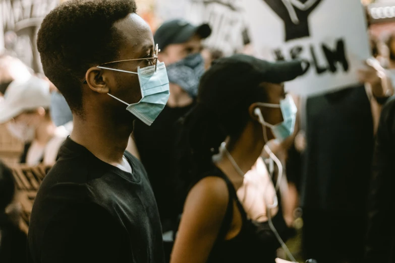 a man in black shirt wearing a face mask in crowd