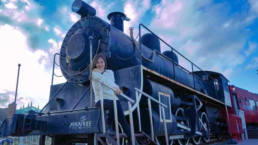 a woman leaning on an old train car