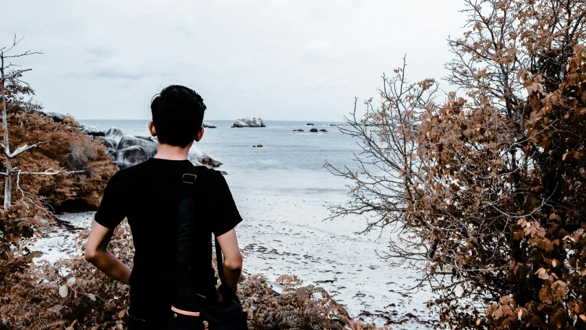 the man is looking out at the ocean