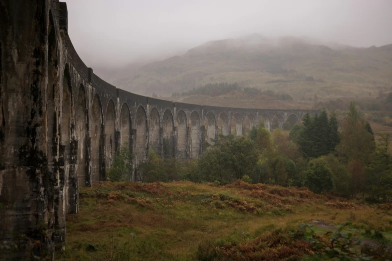 foggy day at an old train bridge near a hill