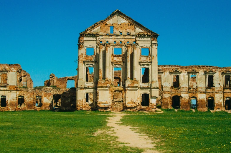 an old building sitting in the middle of grass