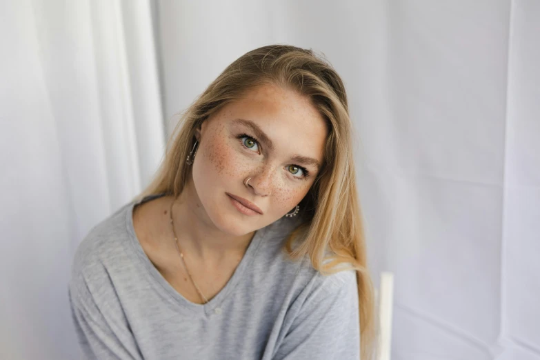 a young woman with shoulder length bangs is sitting