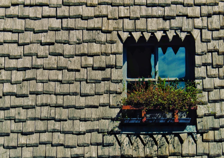 a window in a gray brick wall with planters