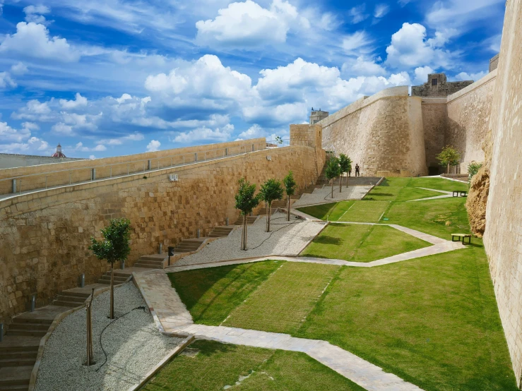 a wide view of a park and grassy areas next to a wall