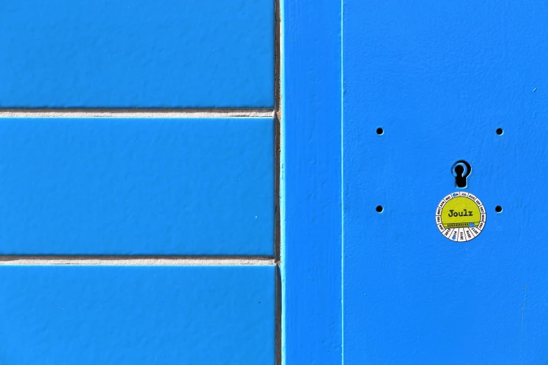 two yellow umbrellas next to blue wall with black handles