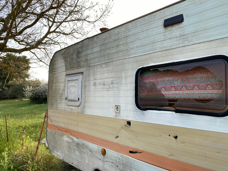 an old camper has a window with a painting on it