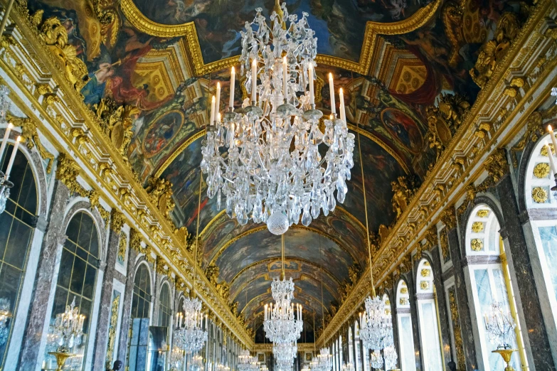 many chandeliers in the large ballroom are decorated with gilded paint